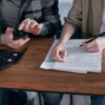 An independent contractor calculating write offs and tracking tax forms to maximize freelance deductions.