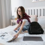 An American college student earning money from a dorm room layout using a laptop without owning a car