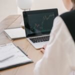 How to Invest in Actively Managed ETFs for Outperformance A young adult using a tablet and smartphone to review real time market charts and actively managed ETF performance data.