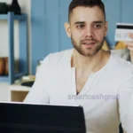 How to Build Credit in College: A Step-by-Step Guide for Students & Parents A college student sitting at a desk in a dorm room holding a credit card while checking credit score options on a laptop.