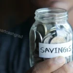 How to Score College Emergency Retention Grants and Build a Cash Buffer in 2026 A glass jar labeled Emergency Fund filled with folded dollar bills sitting on an outdoor brick terrace.