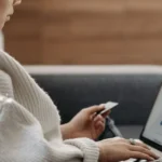 How to Build Credit with Utility Bills in College: A Student's Guide to Free Score Boosts in 2026 A student sitting at an apartment desk, tracking their monthly WiFi and electric bills on a laptop to report alternative data to credit bureaus.