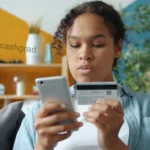 From Ghost Credit to 750+: The 2026 Student Guide to Building Credit with No History A close-up shot of a student happily checking their financial profile and credit score on a mobile application.