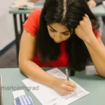 Payment Options for Student Loans: Choosing What Fits You A student sitting at a wooden desk analyzing student loan letters next to a laptop and a calculator.